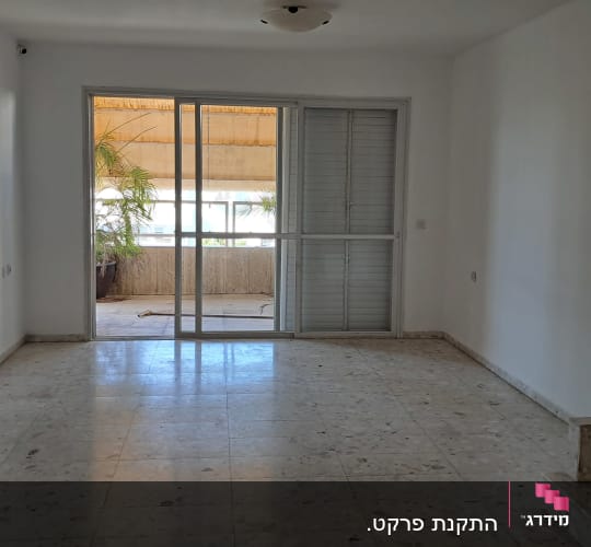 חדר ריק עם רצפת שיש ודלת זכוכית למרפסת